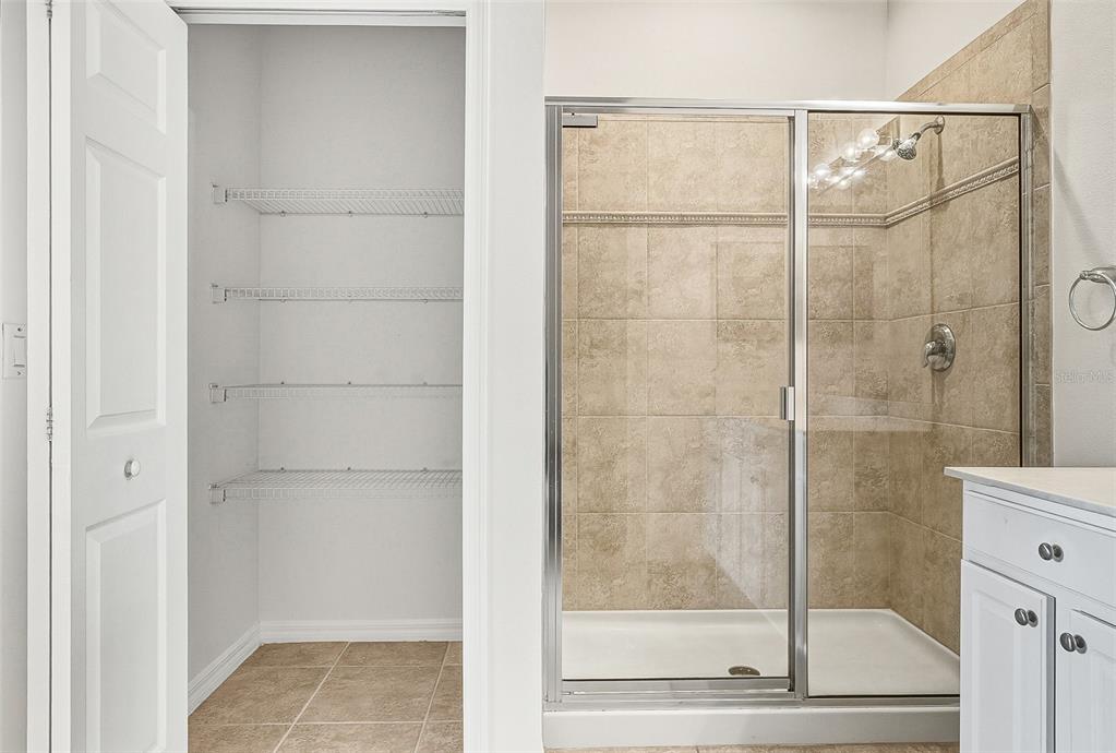 7928 Limestone Lane, Unit 19105 Sarasota, FL 34233 - Photo 28 of 37 a bathroom with a glass shower door