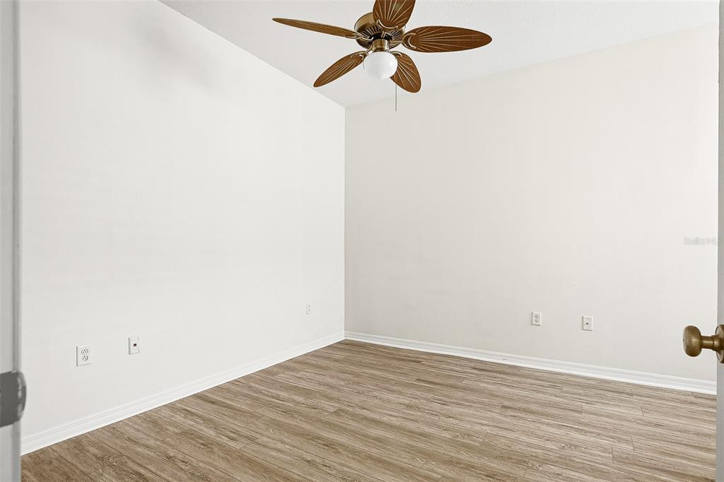 7928 Limestone Lane, Unit 19105 Sarasota, FL 34233 - Photo 33 of 37 a view of a room with wooden floor ceiling fan