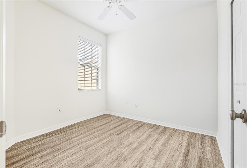 7928 Limestone Lane, Unit 19105 Sarasota, FL 34233 - Photo 35 of 37 an empty room with wooden floor and windows