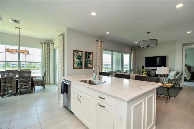 a view of kitchen with kitchen island a sink a counter top space and living room