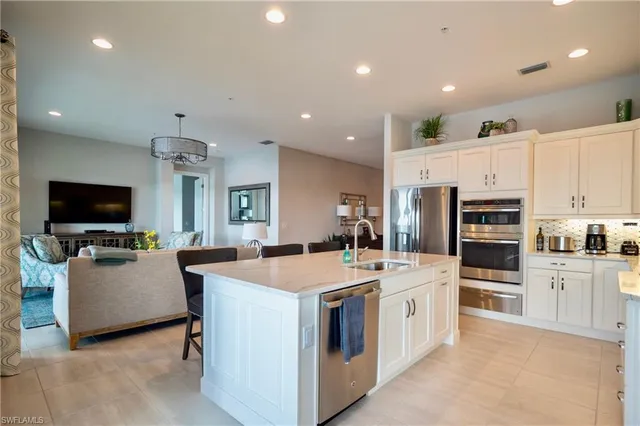 a large white kitchen with a stove a sink a microwave and a refrigerator