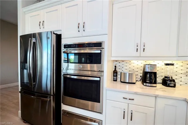 a kitchen with refrigerator and cabinets