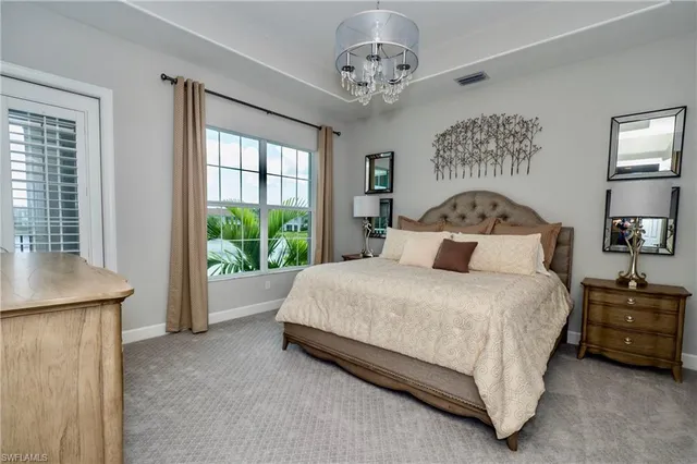 a bedroom with a large bed and a chandelier