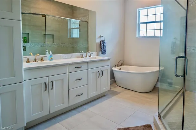 a bathroom with a double vanity sink mirror and bathtub