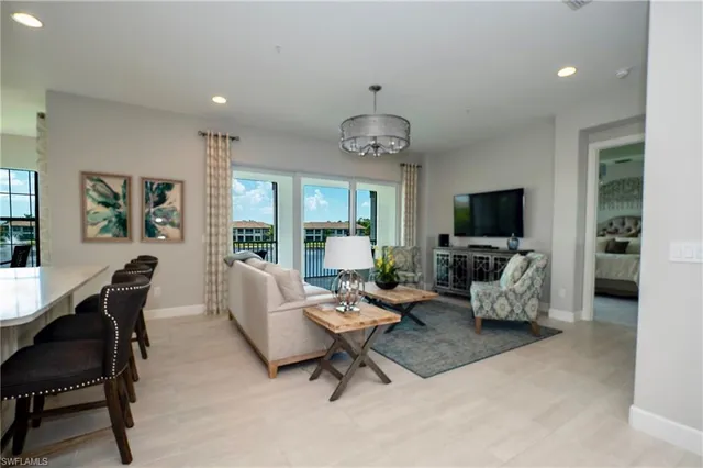 a living room with furniture a chandelier and a flat screen tv