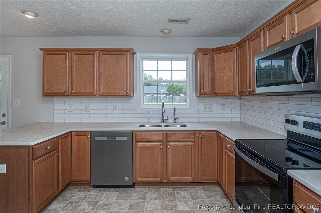 7650 Rufus Johnson Road Fayetteville, NC 28306 - Photo 15 of 43 a kitchen with a sink stove and microwave