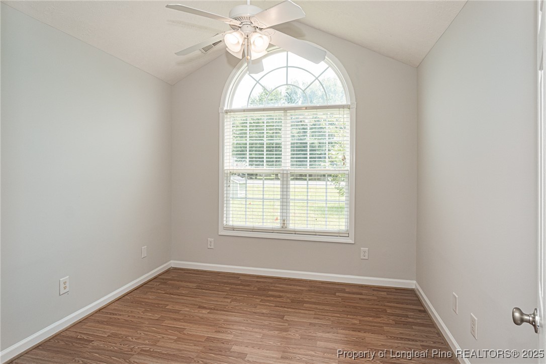 7650 Rufus Johnson Road Fayetteville, NC 28306 - Photo 34 of 43 an empty room with wooden floor exposed radiator and windows