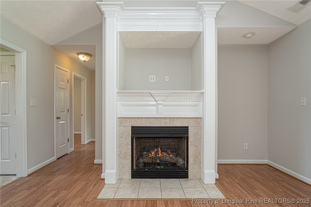 7650 Rufus Johnson Road Fayetteville, NC 28306 - Photo 8 of 43 a living room with a fireplace and wooden floor