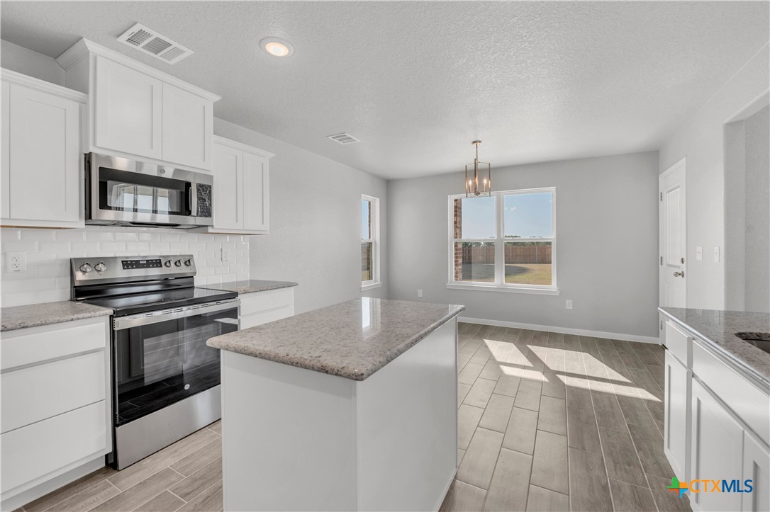 215 Overlook Trail Copperas Cove, TX 76522 - Photo 14 of 36 a kitchen with granite countertop a stove sink and microwave