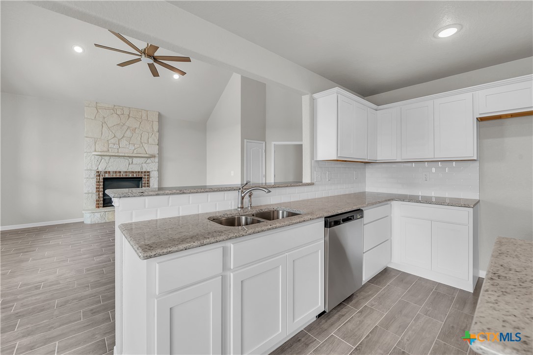 215 Overlook Trail Copperas Cove, TX 76522 - Photo 16 of 36 a kitchen with stainless steel appliances granite countertop a sink dishwasher and white cabinets with wooden floor