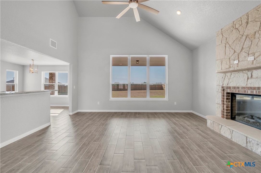 215 Overlook Trail Copperas Cove, TX 76522 - Photo 7 of 36 an empty room with wooden floor a fireplace and windows