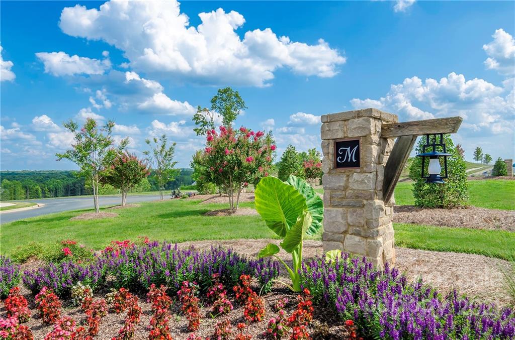 7230 Waterwheel Street Southwest, Unit 100 Concord, NC 28025 - Photo 17 of 23 a front view of a house with a yard and fountain in middle of green field