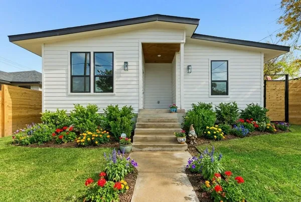 a front view of a house with a garden