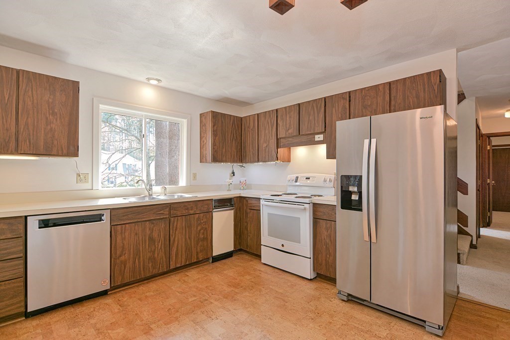 22 Wildwood Road Stow, MA 01775 - Photo 12 of 35 a kitchen with granite countertop stainless steel appliances a refrigerator sink and microwave