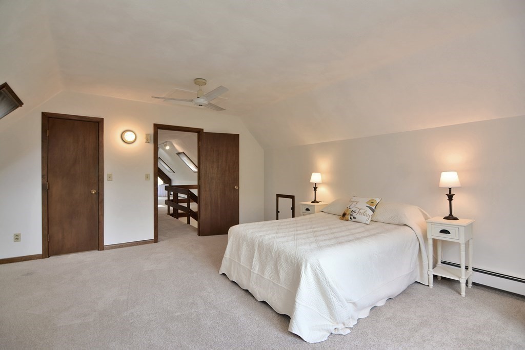 22 Wildwood Road Stow, MA 01775 - Photo 25 of 35 a spacious bedroom with a bed and a lamp