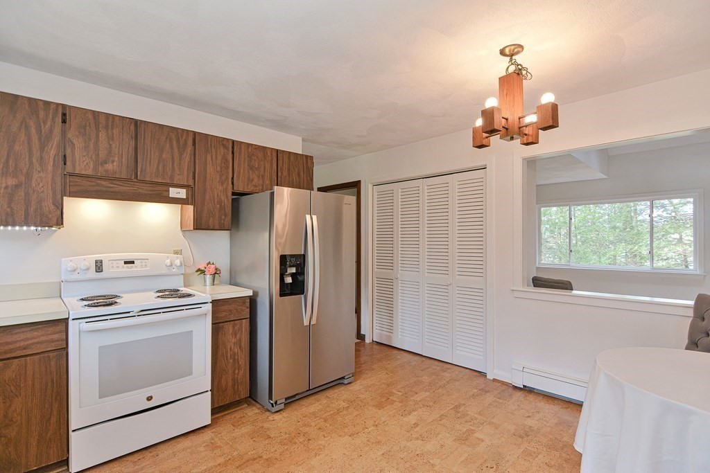 22 Wildwood Road Stow, MA 01775 - Photo 10 of 35 a kitchen with stainless steel appliances a stove a refrigerator and cabinets