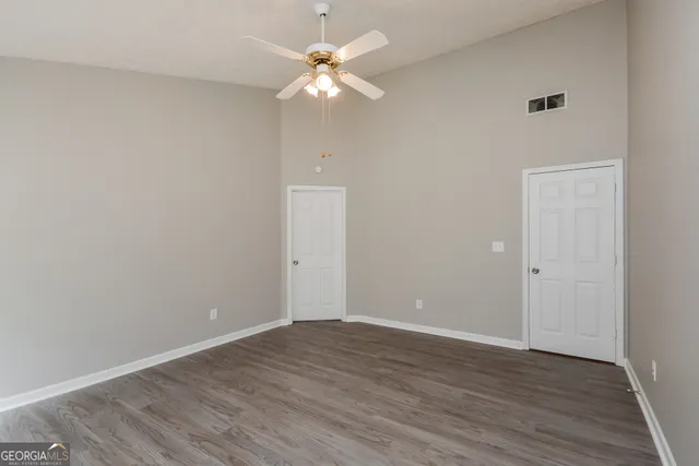 a view of an empty room with wooden floor