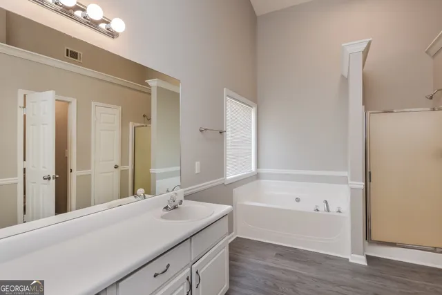 a bathroom with a tub sink and mirror