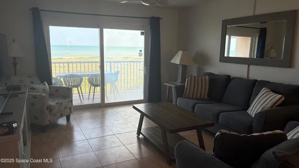 a living room with furniture and a floor to ceiling window