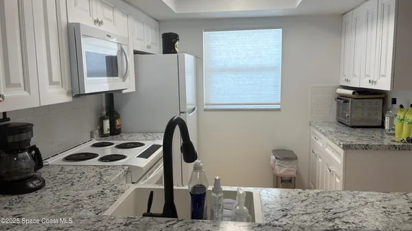 a kitchen with stainless steel appliances kitchen island a stove a sink a refrigerator and cabinets