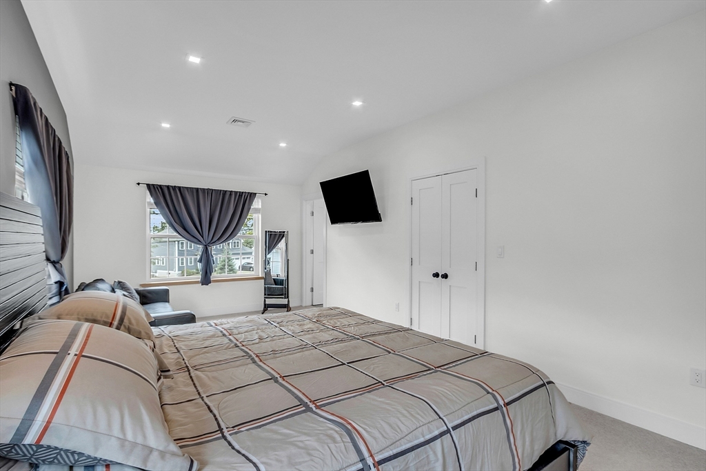 2253 Washington Street, Unit 2 Canton, MA 02021 - Photo 15 of 39 a bedroom with a large bed and a flat tv screen on dresser