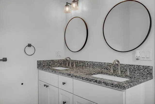 a bathroom with a granite countertop sink and a mirror