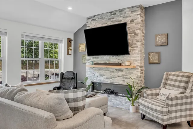 a living room with furniture a flat screen tv and a fireplace