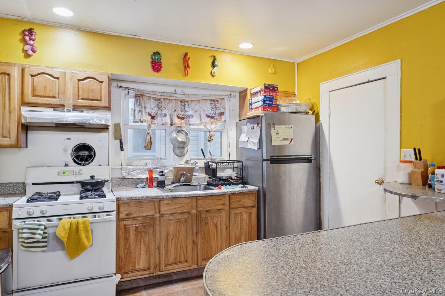 13 Academy Street Patchogue, NY 11772 - Photo 3 of 7 a kitchen with stainless steel appliances a sink stove and refrigerator