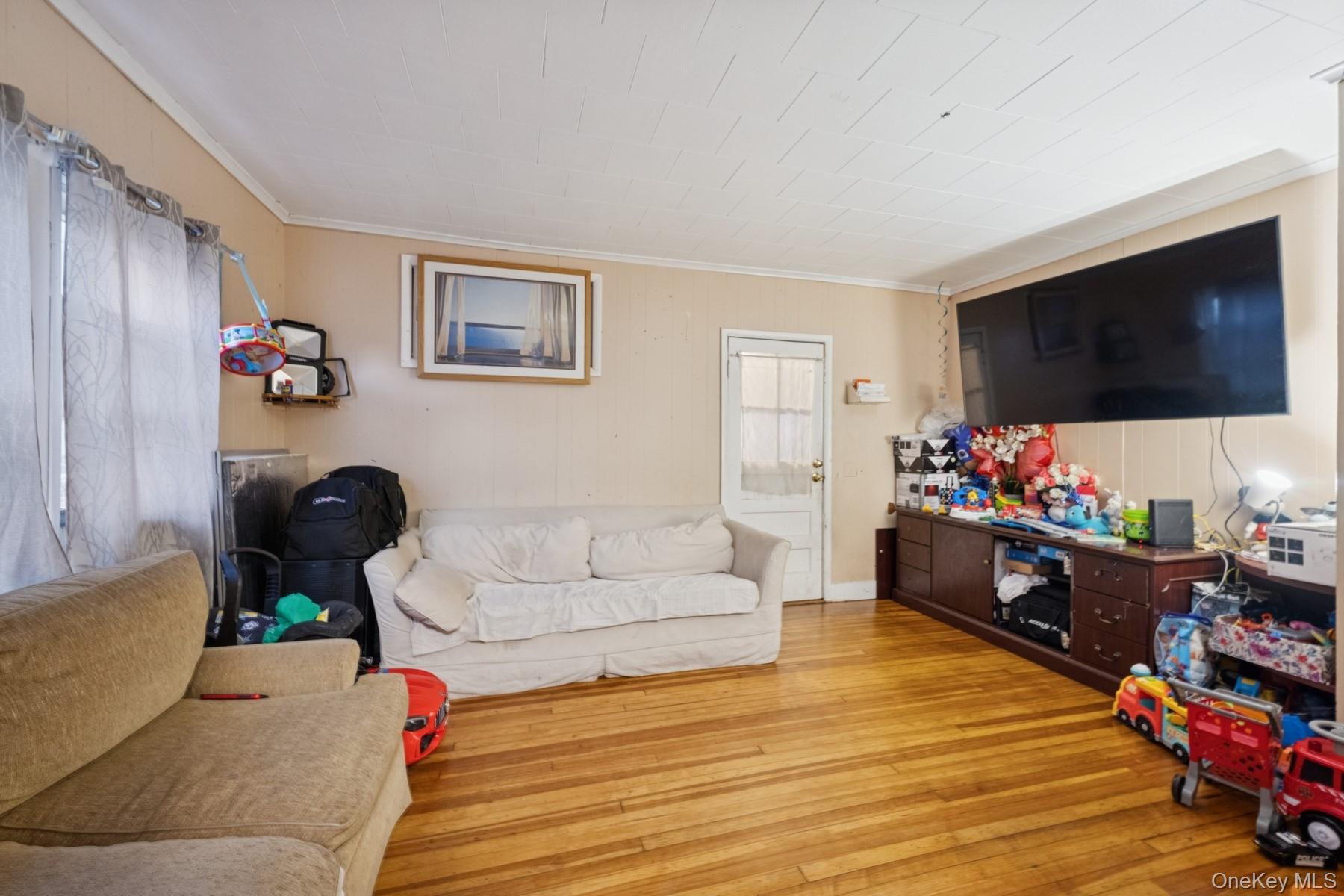 13 Academy Street Patchogue, NY 11772 - Photo 4 of 7 a living room with furniture and a flat screen tv