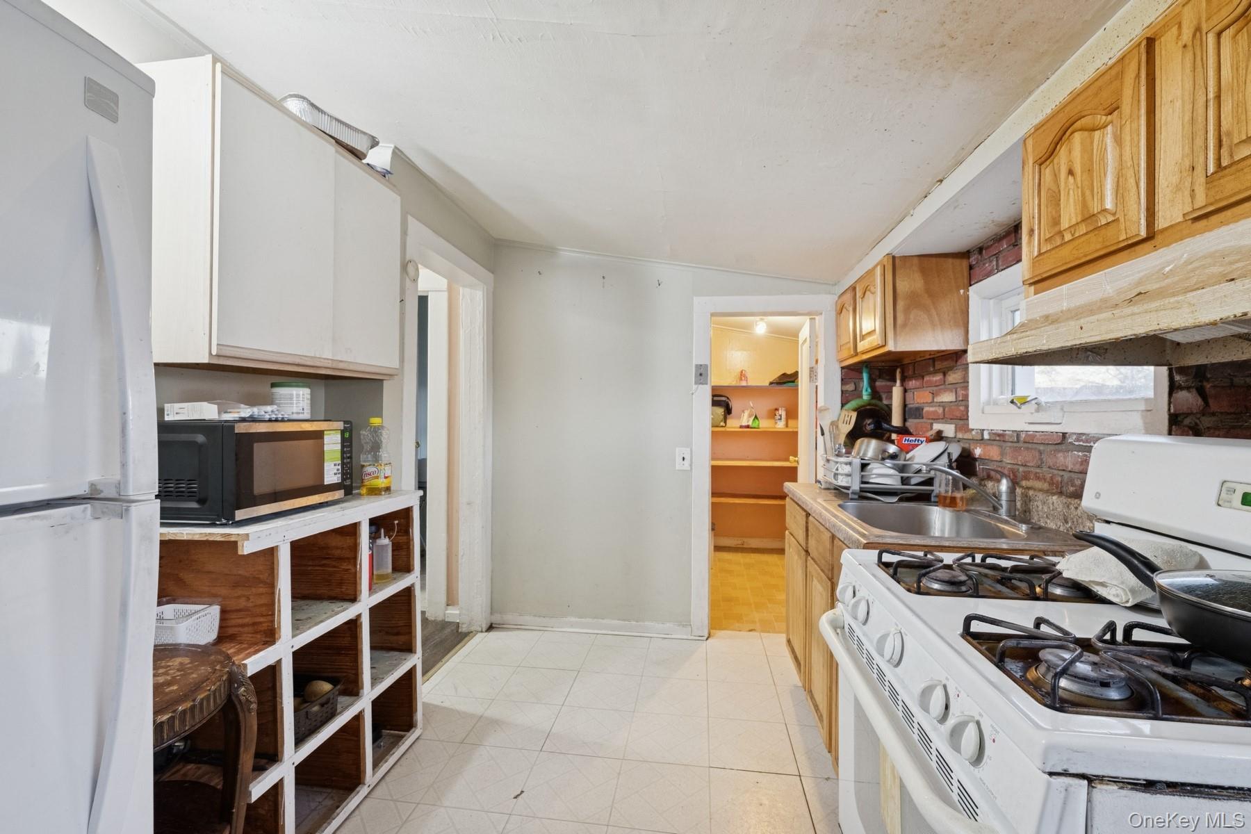 13 Academy Street Patchogue, NY 11772 - Photo 6 of 7 a kitchen with a stove and a refrigerator