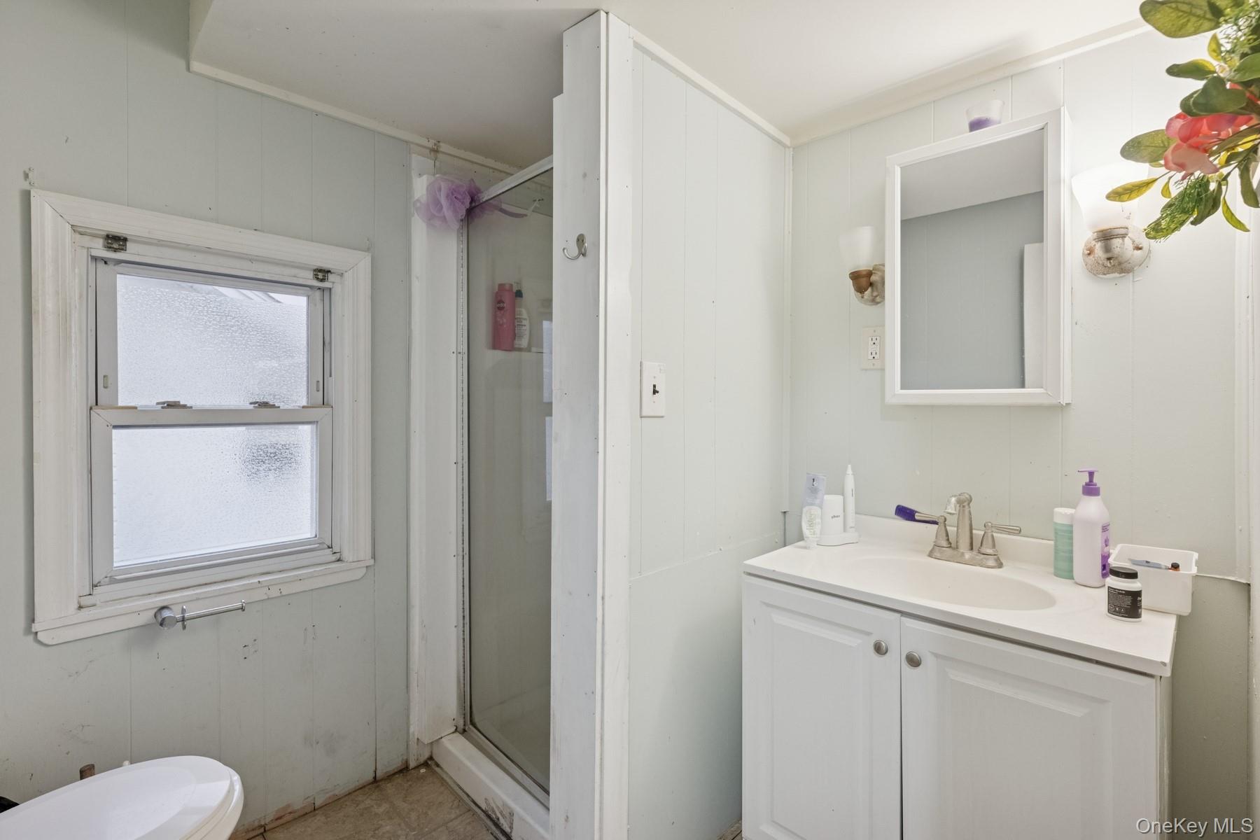13 Academy Street Patchogue, NY 11772 - Photo 7 of 7 a bathroom with a sink toilet and vanity