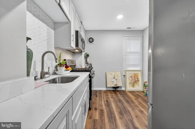 a kitchen with a sink a stove and cabinets