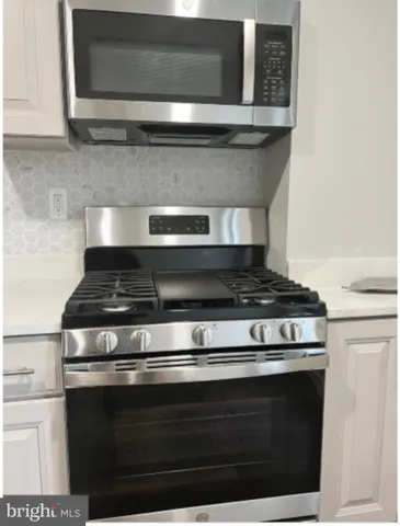 a stove top oven sitting inside of a kitchen