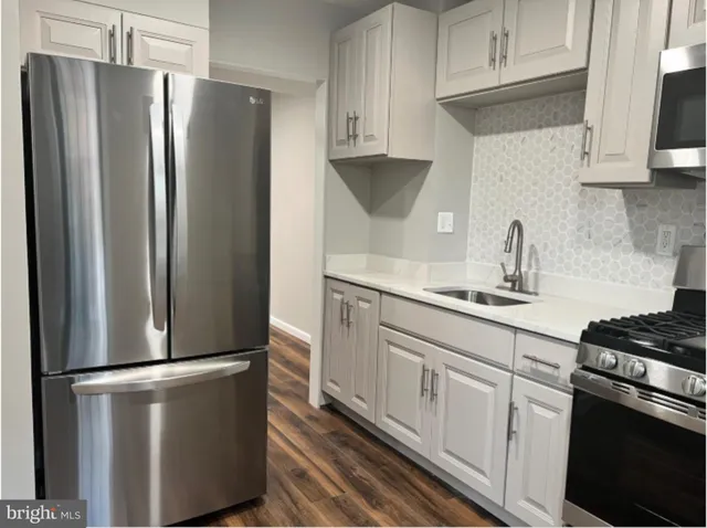 a kitchen with stainless steel appliances a refrigerator sink and cabinets