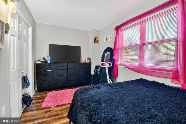 a bedroom with a bed and a lamp on dresser