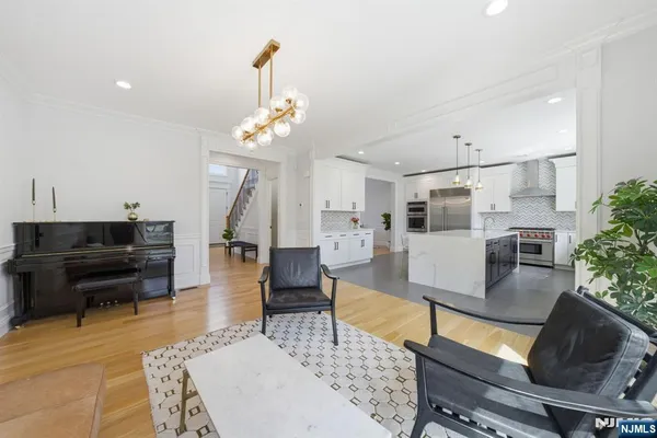 a view of a hallway with wooden floor and a bathroom