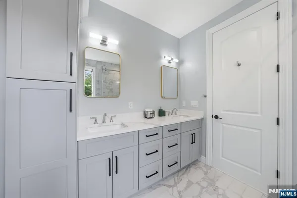 a bathroom with a toilet sink vanity and shower