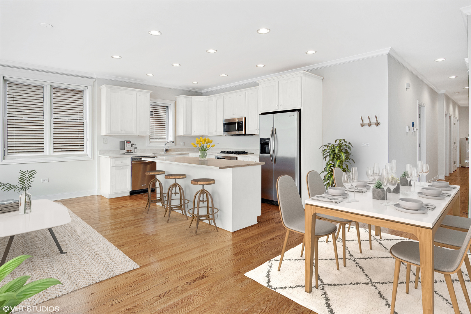 1502 West Augusta Boulevard, Unit 3W Chicago, IL 60642 - Photo 6 of 23 a kitchen with stainless steel appliances kitchen island granite countertop a stove a sink a refrigerator and white cabinets with wooden floor