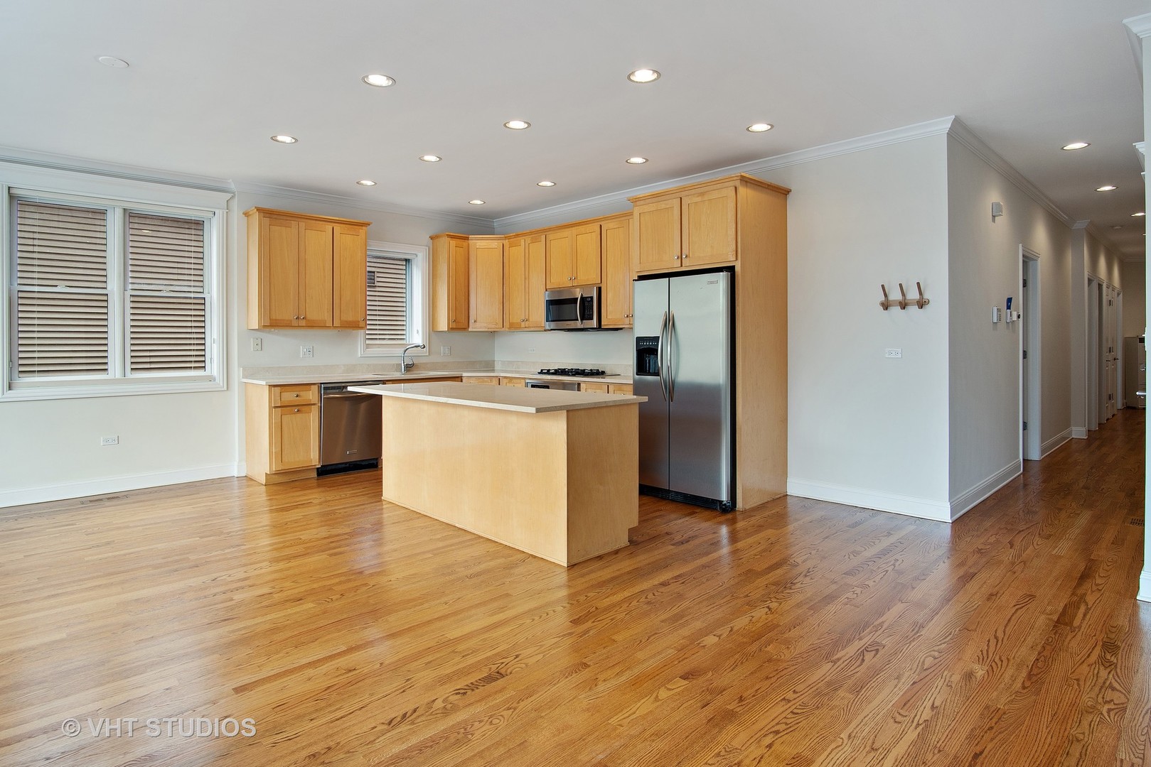 1502 West Augusta Boulevard, Unit 3W Chicago, IL 60642 - Photo 7 of 23 a kitchen with stainless steel appliances granite countertop a stove a refrigerator a sink a microwave and island with wooden floor