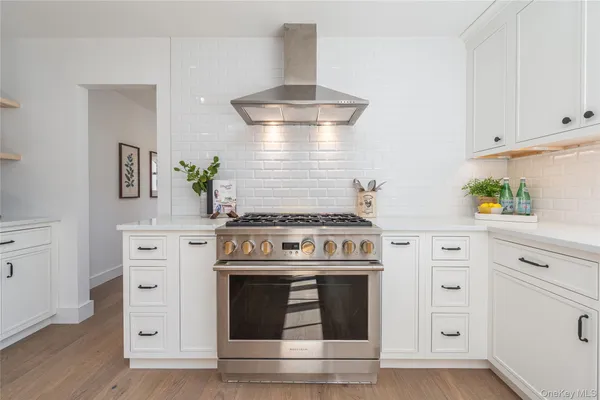 a kitchen with white cabinets and appliances