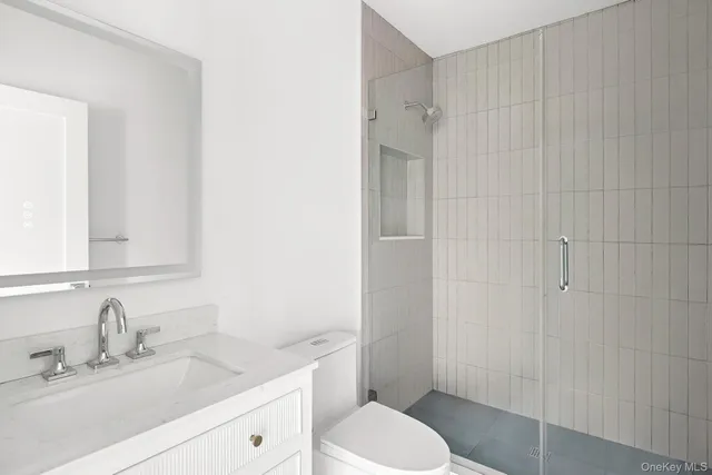 a bathroom with a sink toilet vanity and shower