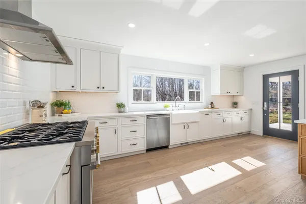 a kitchen with white cabinets and white appliances