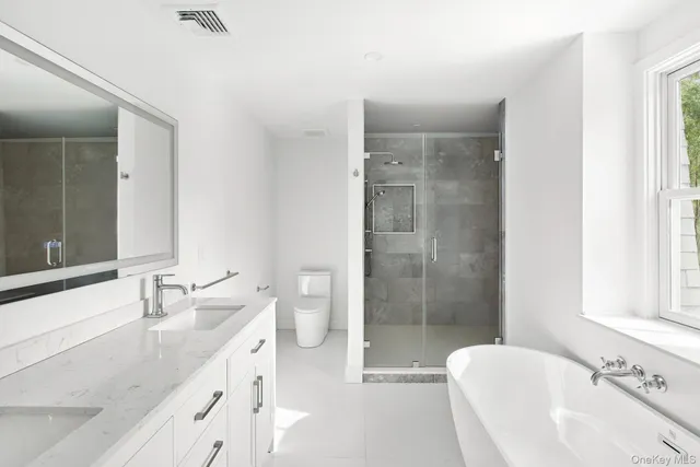 a bathroom with a granite countertop sink a toilet and shower