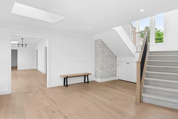 a view of an empty room with wooden floor and stairs