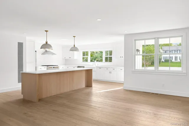 a kitchen with granite countertop a stove a sink and a large window