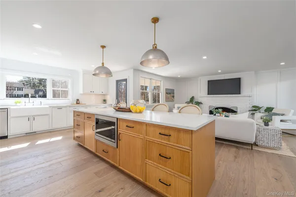 a kitchen with kitchen island granite countertop a sink cabinets and wooden floor