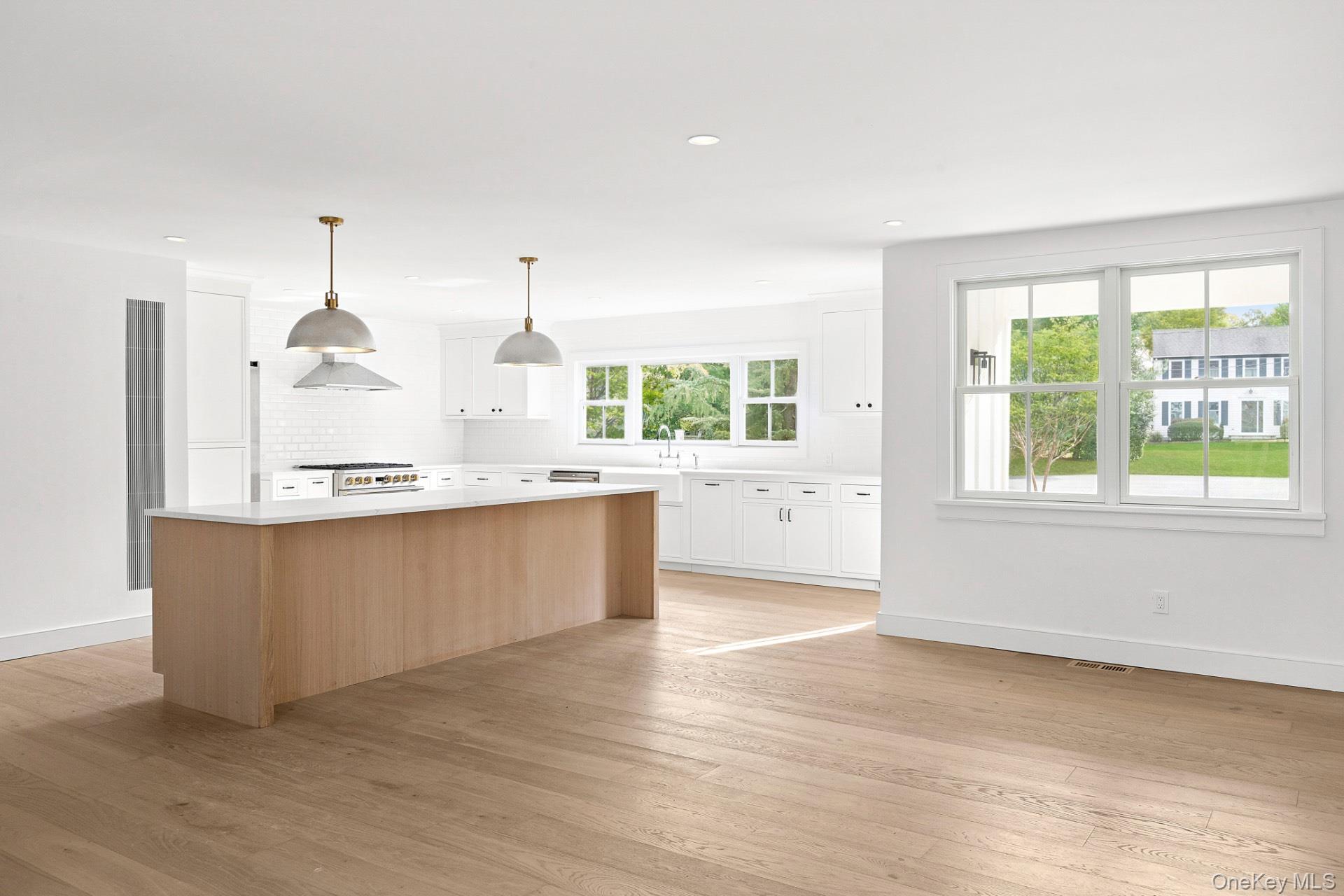 5 Pheasant Lane Remsenburg, NY 11960 - Photo 6 of 27 Kitchen featuring white cabinets, a center island, hanging light fixtures, light wood-style floors, and recessed lighting