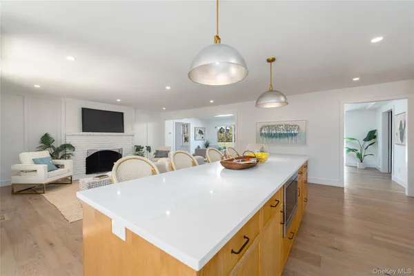 a living room with stainless steel appliances kitchen island a table chairs and a couch