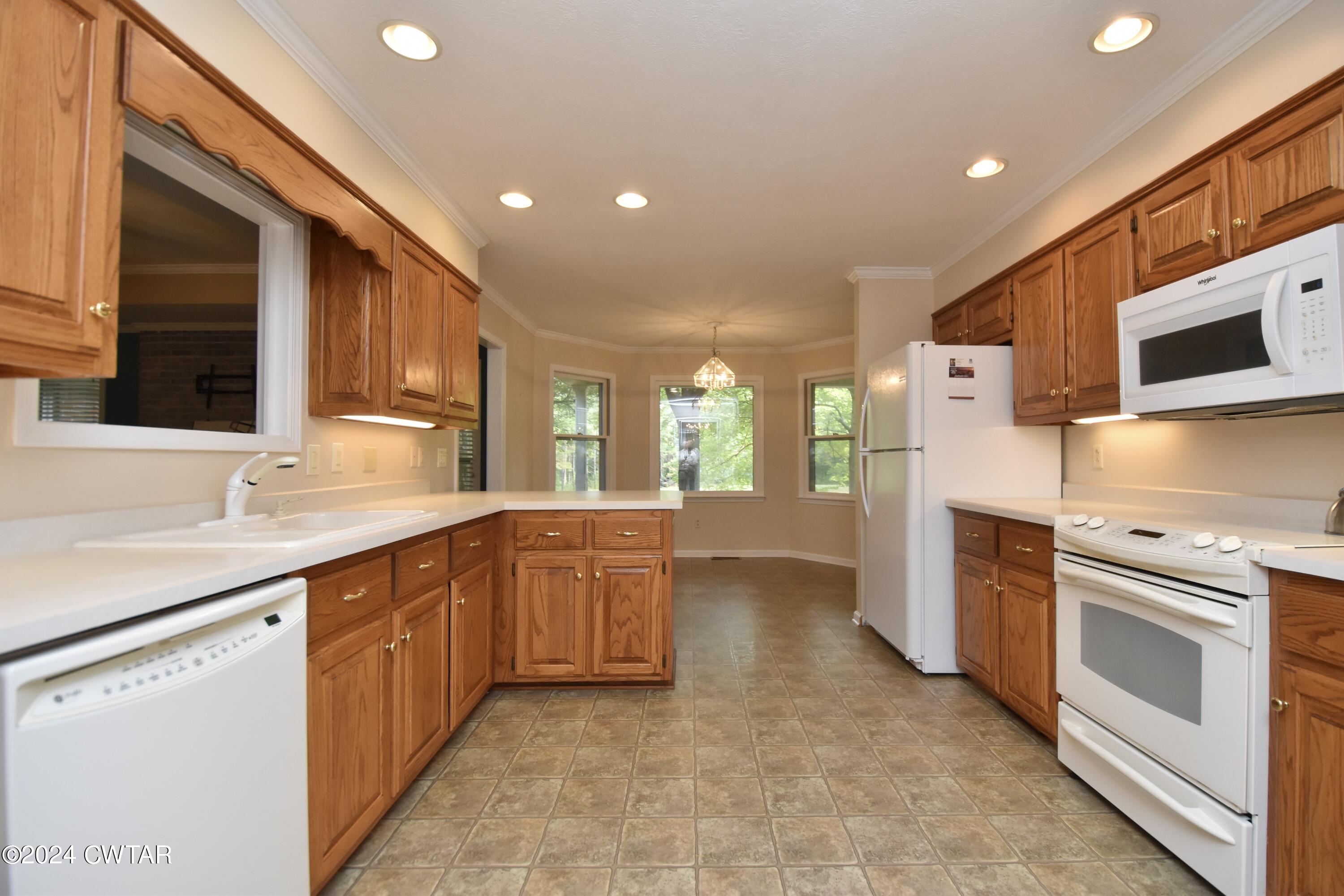 63 Deep Gap Road Jackson, TN 38301 - Photo 9 of 31 a kitchen with stainless steel appliances granite countertop a stove a sink and a microwave