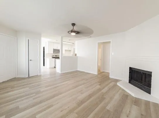 a view of empty room with wooden floor and fireplace